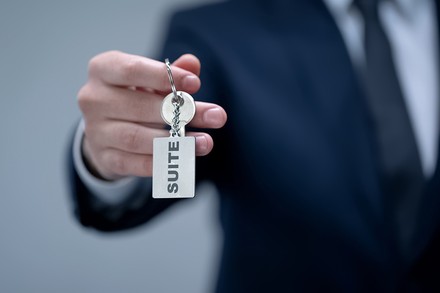 Ein Hotelier übergibt den Gast den Schlüssel zu einer Suite