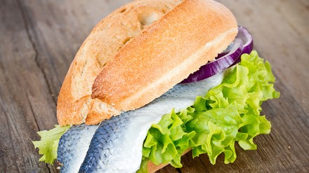 Ein Bismarckhering und ein paar Zwiebelringe zwischen zwei Brötchenhälften – das ist das klassische Fischbrötchen in seiner einfachsten Form. (Foto: © Thomas Francois/stock.adobe.com) Ein frisch belegtes Brötchen mit Bismarckhering, Salat und Zwiebelringen.