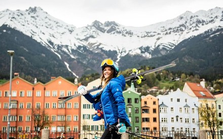 Julia Mancuso mit Skiern vor einem Bergpanorama in Österreich