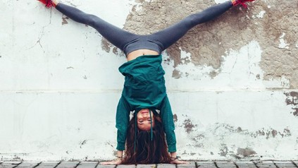 Frau macht Spagat kopfüber