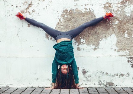 Frau macht Spagat kopfüber