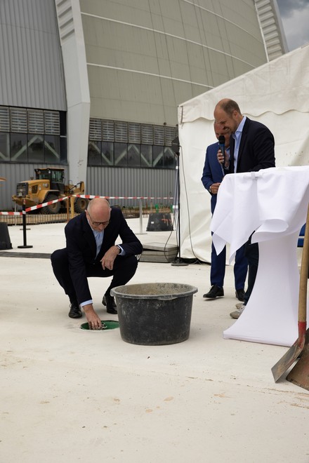 Ministerpräsident Dr. Dietmar Woidke versenkt die Zeitkapsel im Fundament des Hotelneubaus Ohana Lodge.