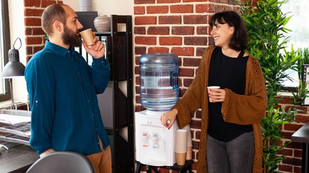 Die Mitgliedsunternehmen des BDV Vending bieten eine Vielzahl von Möglichkeiten, um innerhalb der Betriebsverpflegung eine optimale Versorgung mit qualitativ hochwertigem Trinkwasser sicherzustellen. (Foto: © DC Studio/stock.adobe.com) Arbeitnehmer an einem Wasserspender