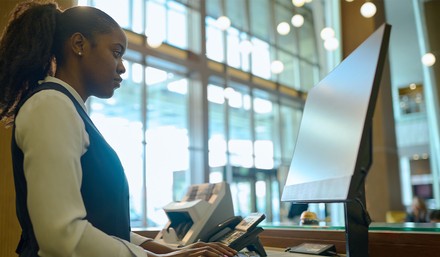 Mitarbeiter im Gastgewerbe greifen oft zu sehr schwachen Passwörtern für ihre beruflichen Accounts. (Foto: © pressmaster/stock.adobe.com) Mitarbeiterin an der Rezeption vor einem Computer