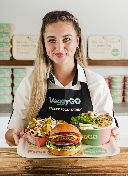 Frau präsentiert Burger von VeggyGo