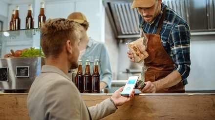 Deutsche Jugendliche zahlen immer häufiger bargeldlos. (Foto: © Gorodenkoff/stock.adobe.com) Ein junger Mann zahlt via App an einem Foodtruck.