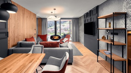 Großzügiger Wohnraum mit stylischem Kamin und Essbereich in der Top Suite Deluxe. (Foto: © Matthias Dengler) Großzügiger Wohnraum mit stylischem Kamin und Essbereich in der Top Suite Deluxe im Edelweiss Salzburg Mountain Resort .