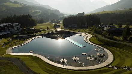 Der organisch designte Spa „Atmosphere by Krallerhof“, der 5.500 m2 große Natur-Badesee und der 50 Meter lange Infinity-Pool fügen sich harmonisch in die Landschaft ein. (Foto: © Krallerhof) Der organisch designte Spa „Atmosphere by Krallerhof“, der 5.500 m2 große Natur-Badesee und der 50 Meter lange Infinity-Pool fügen sich harmonisch in die Landschaft ein.