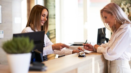 In Zukunft muss in Hotels nicht mehr für jeden einzelnen Gast ein Meldeschein ausgefüllt werden. (Foto © Kalim/stock.adobe.com) Frau unterschreibt an der Rezeption