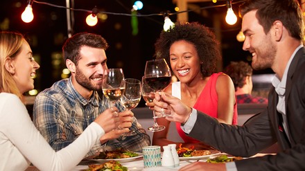 In den warmen Sommermonaten sitzt man gerne länger im Freien. (Foto: © Monkey Business / stock.adobe.com) Eine Gruppe von Freunden sitzt im Außenbereich eines Restaurants zusammen und diniert.