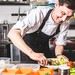 Koch schält Zucchini in der Küche