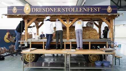 Bäcker bestreuen Riesenstollen mit Puderzucker