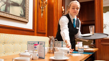 Sophie Cyriax beim Eindecken von Tischen im Hotelrestaurant