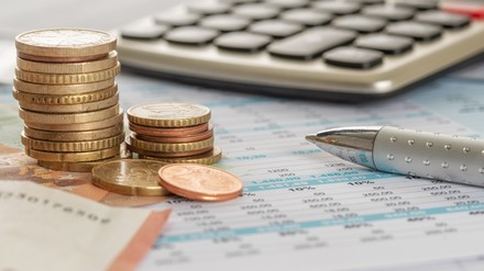 Geld mit Taschenrechner und Kugelschreiber