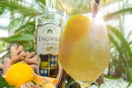 Ein Cocktail neben einer Likörflasche