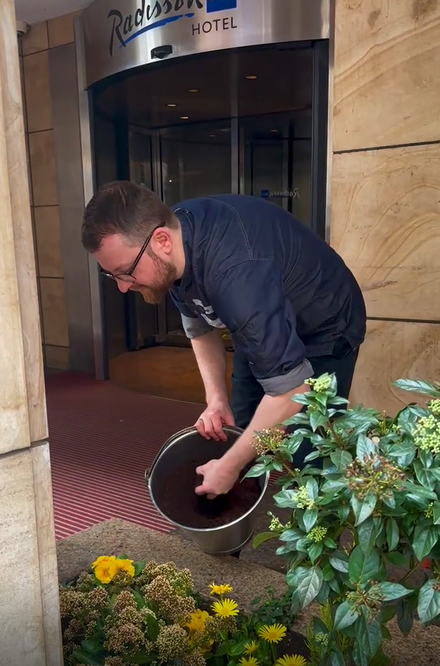 Tim Hoffmann verstreut Kaffeesatz als Dünger