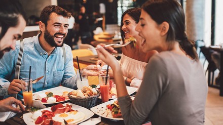 Gäste in einem Restaurant beim Essen. Zwei Männer, zwei Frauen. (Foto: © stock.adobe.com/Djile)