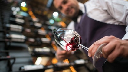 Kellner schenkt Wein in ein Glas ein