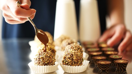 Zwei verschiedene Desserts werden von einer weiblichen Hand zubereitet