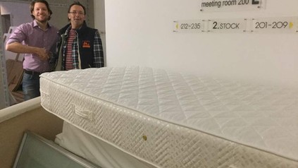 Zwei Männer hinter Matratze