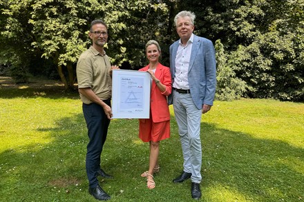 Drei Mitarbeiter von Klüh präsentieren die Auszeichnung