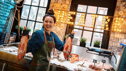 Junge Frau hält einen Fisch in der Hand