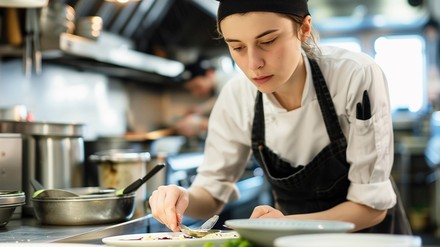 Junge Köchin beim Anrichten