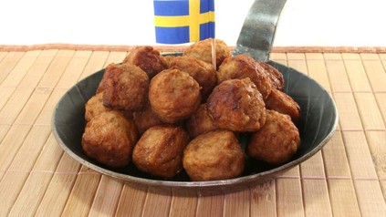 Köttbullar mit einer schwedischen Flagge in einer Pfanne