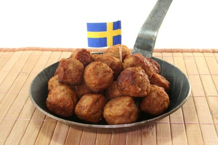 Köttbullar mit einer schwedischen Flagge in einer Pfanne