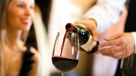 Ein Glas Wein wird eingeschenkt