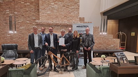 Wirtschaftsminister, Claus Ruhe Madsen, überreicht dem Vorsitzenden des Holstein Tourismus e.V., Andreas Köhler, die Urkunde zur LTO-Anerkennung.