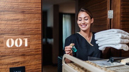 Junge Frau reinigt ein Hotelzimmer