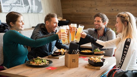 Gäste stoßen mit Bier in einem Restaurant an