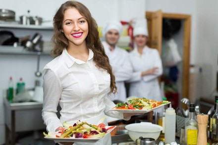Frau hält zwei Teller mit Essen in der Hand