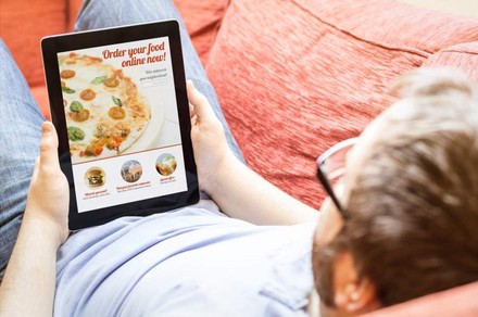 Mann bestellt sich Essen via Tablet