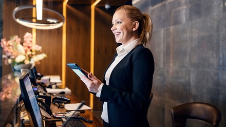 Junge Rezeptionistin in einem Hotel hinter dem Empfangstresen