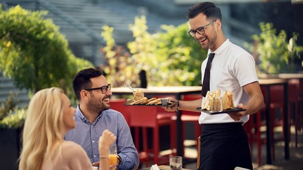 Kellner bringt Essen an den Tisch