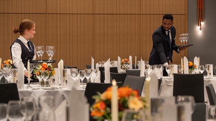 Maritim Hotel Würzburg mit zwei Mitarbeitern der Gastronomie die Tische eindecken