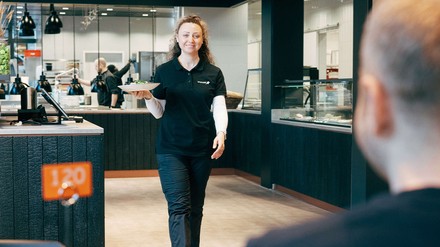 Junge Frau serviert Speisen auf einen Tablett