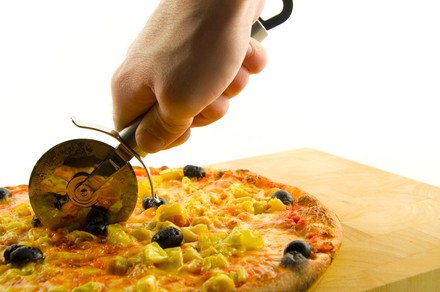 Pizzaschneider schneidet Pizza