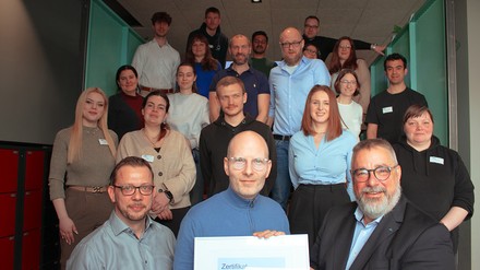 CEO Oliver Winter (M.). Christian Hempel-Werner (l.) und Olaf Seiche, TÜV Rheinland (r.) mit a&o-Team bei der offiziellen Übergabe des ISO 9001-Zertifikats in Berlin