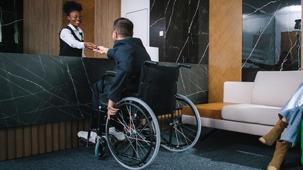 Rollstuhlfahrer an der Rezeption