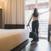 Frau steht am Fenster eines Hotelzimmers