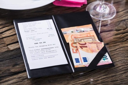 Eine Restaurantrechnung und Geldscheine