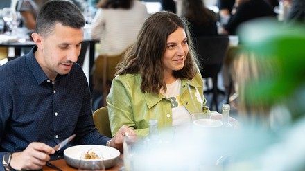 Ein Mann und eine Frau sitzen am Tisch und essen