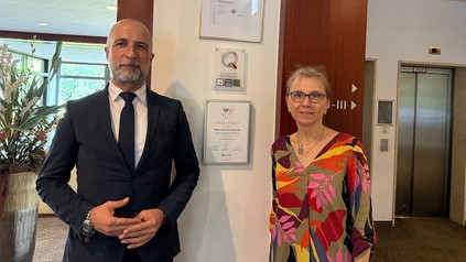 Ergün Ersoy (Residence Manager) und Annette Heim (Verwaltung) vor dem ServiceQ-Siegel