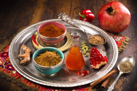 Diverse Gewürze, Körner und ein Öl auf einem Tablet angerichtet