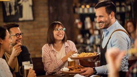 Kellner bringt Essen an den Tisch