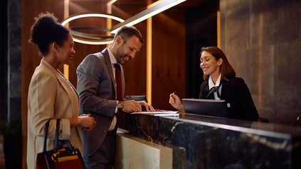 Zwei Reisende beim Check-In an der Rezeption im Hotel