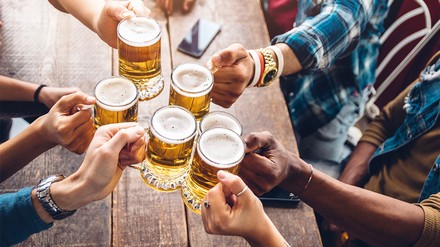 Mehrere Leute stoßen mit Bier an